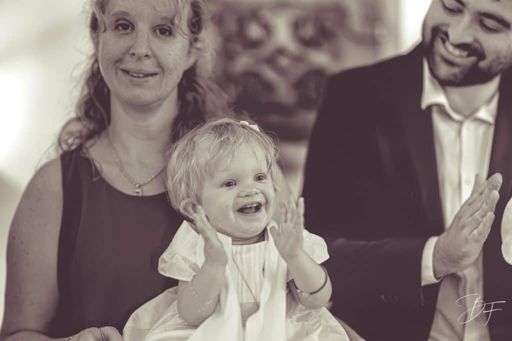 Petite fille riant aux éclats et applaudissant sur les genoux de sa mère, virage sépia, par BFO Photographie