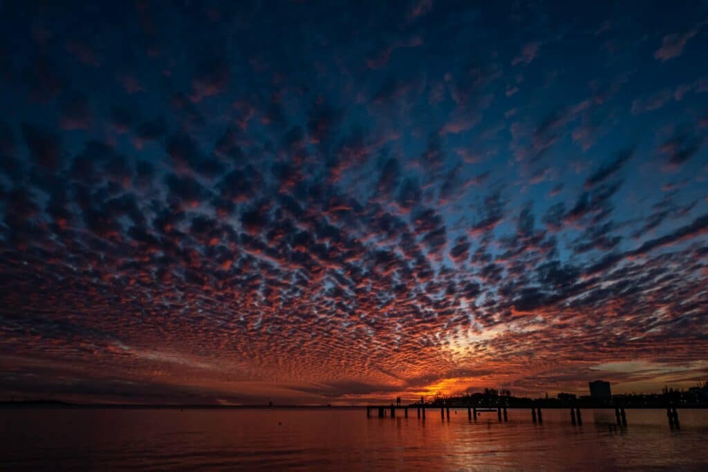 Ciel du crépuscule couvert de nuages au-dessus d'un ponton et de la mer, pose longue par BFO Photographie