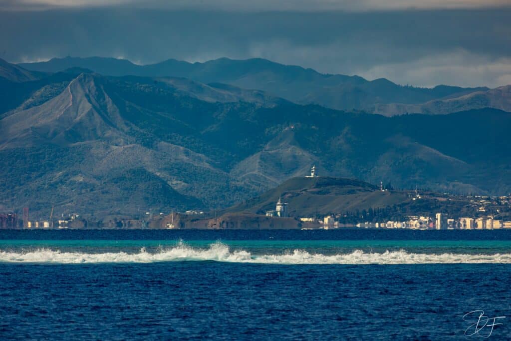 Vagues sur le lagon devant les montagnes bleutées de la Grande Terre, vue depuis Nouméa, par BFO Photographie