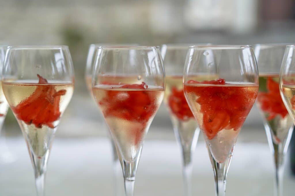 Rangée de coupes de vin pétillant garnies de fruits rouges lors du vin d'honneur, par BFO Photographie
