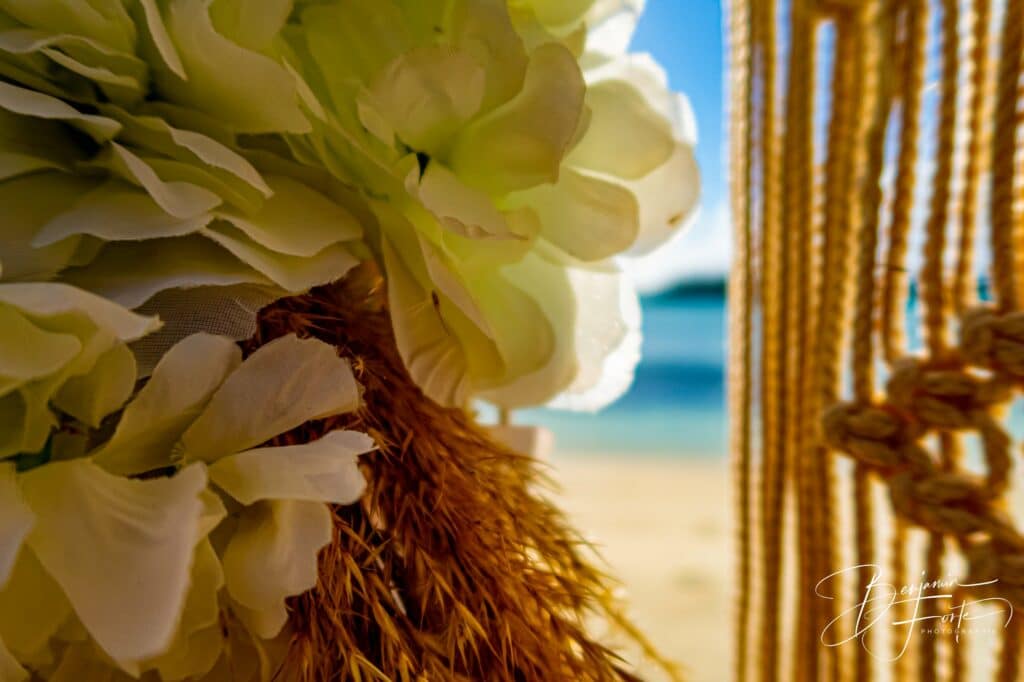 Gros plan sur une fleur blanche et des cordages du décor de cérémonie, mariage en bord de mer par BFO Photographie