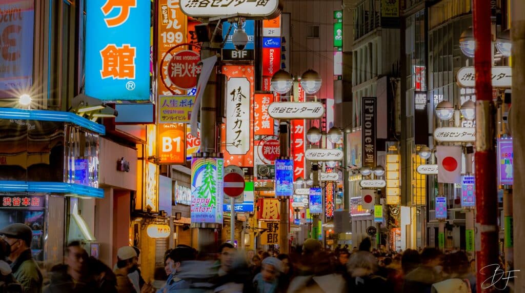 Enseignes lumineuses et néons colorés au-dessus d'une rue animée du Japon la nuit, par BFO Photographie