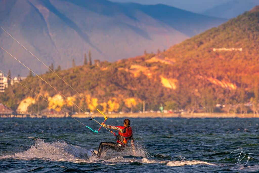 Kitesurfeur sur le lagon de Nouméa devant les collines éclairées par la lumière du soir, par BFO Photographie