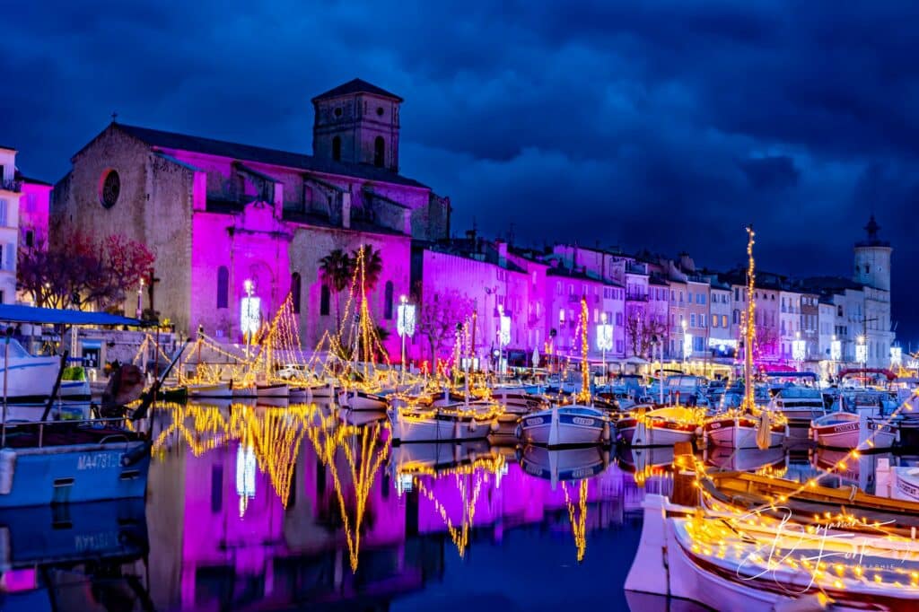 Port de plaisance illuminé de violet la nuit, bateaux et reflets colorés dans l'eau, par BFO Photographie