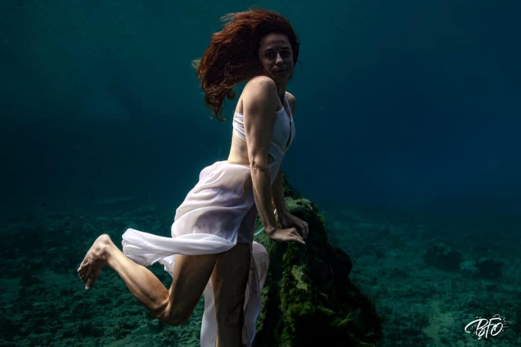 Jeune femme aux cheveux roux en robe blanche sous l'eau, portrait aquatique par BFO Photographie