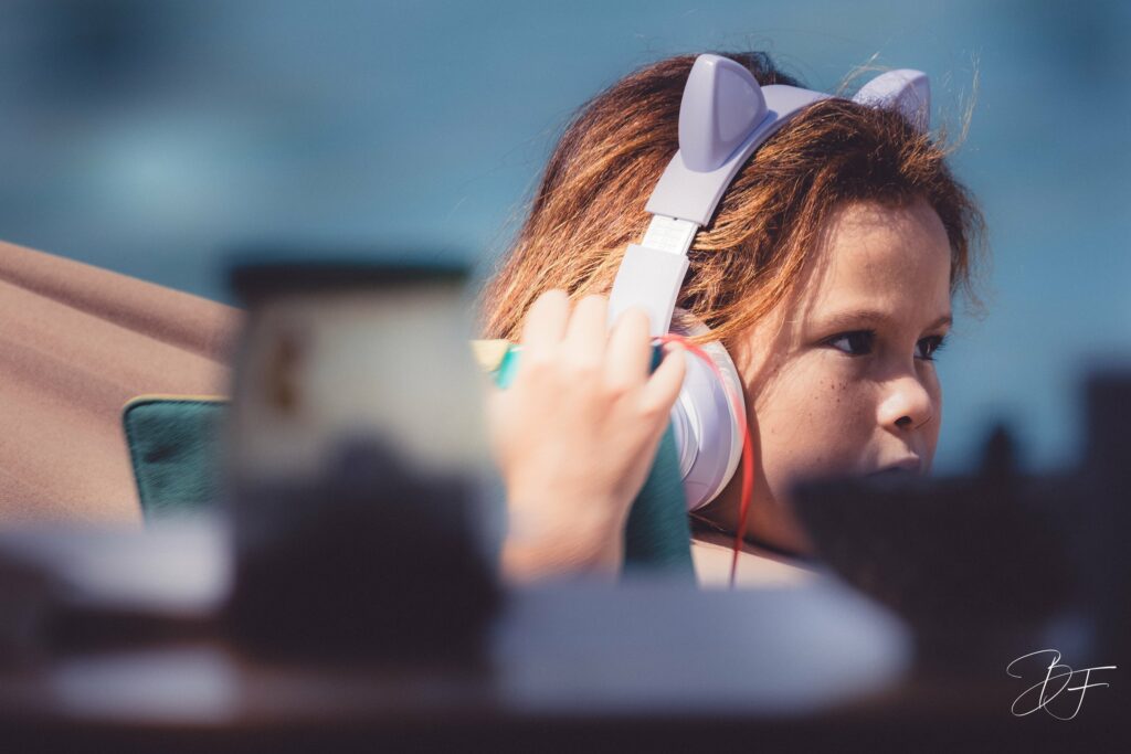 Petite fille portant un casque audio à oreilles de chat, regard concentré, portrait d'enfant par BFO Photographie