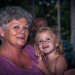 Grand-mère souriante et son petit-enfant blond joue contre joue, portrait de famille par BFO Photographie
