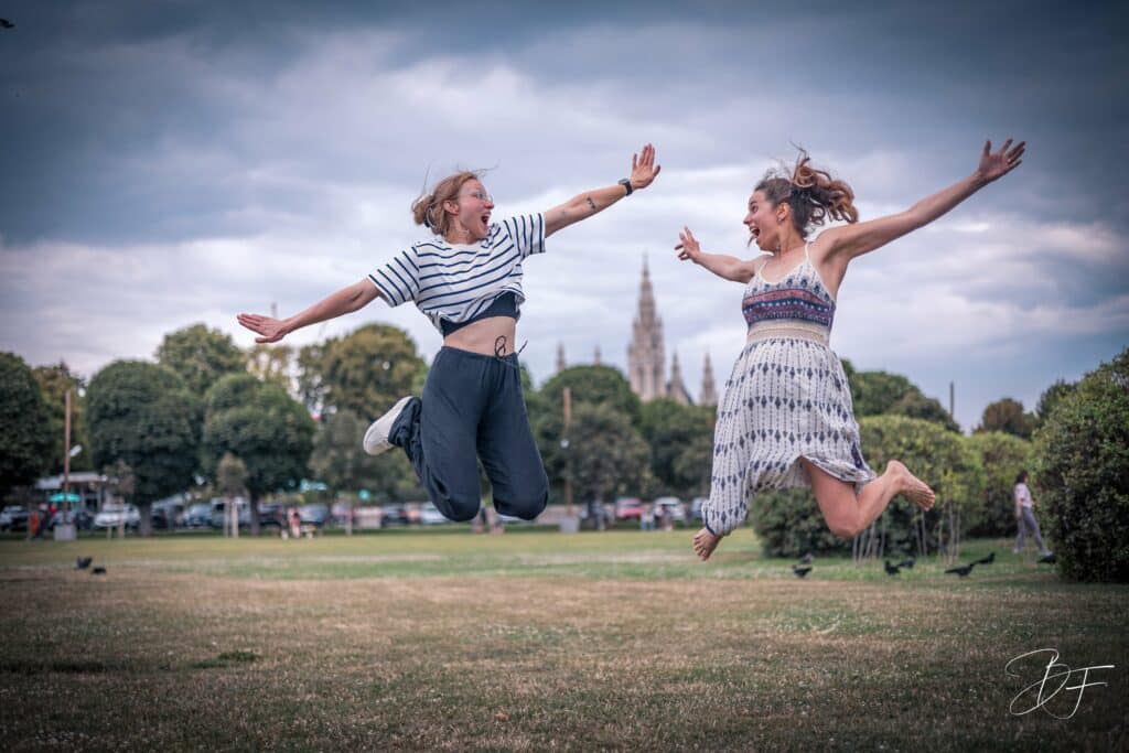 Deux jeunes femmes sautant bras ouverts dans un parc, portrait lifestyle plein d'énergie par BFO Photographie