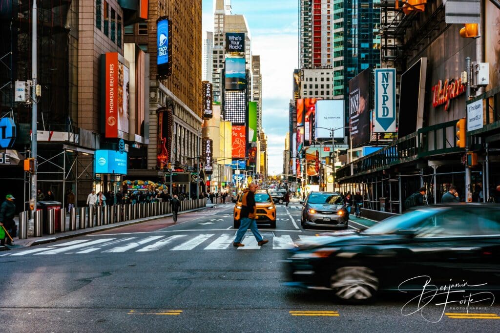Carrefour de New York avec taxis jaunes et voiture en mouvement entre les gratte-ciel, par BFO Photographie