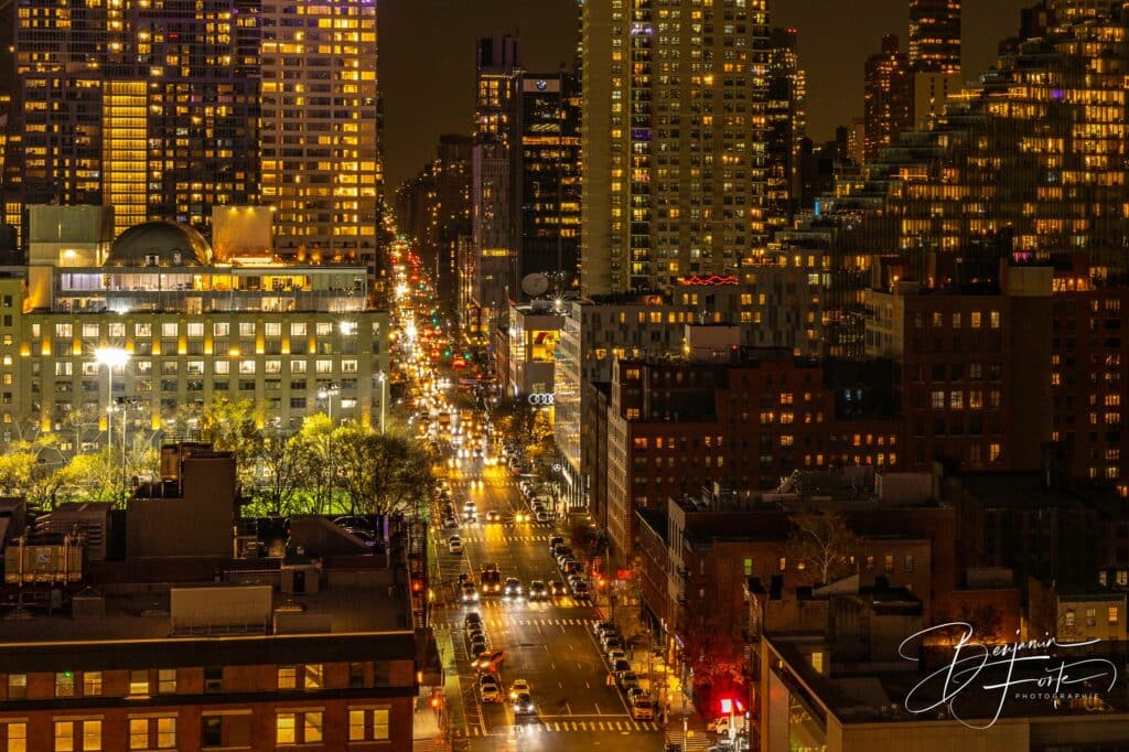 Avenue illuminée entre les immeubles d'une grande ville la nuit, photo urbaine par BFO Photographie