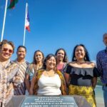 Le bureau de l'association Kumpulan Anak Niaoulis PAÏTA et le maire de Païta, Antoine Romain, souriants devant la stèle du centenaire de la présence indonésienne en Nouvelle-Calédonie, à la mairie de Païta, par BFO Photographie
